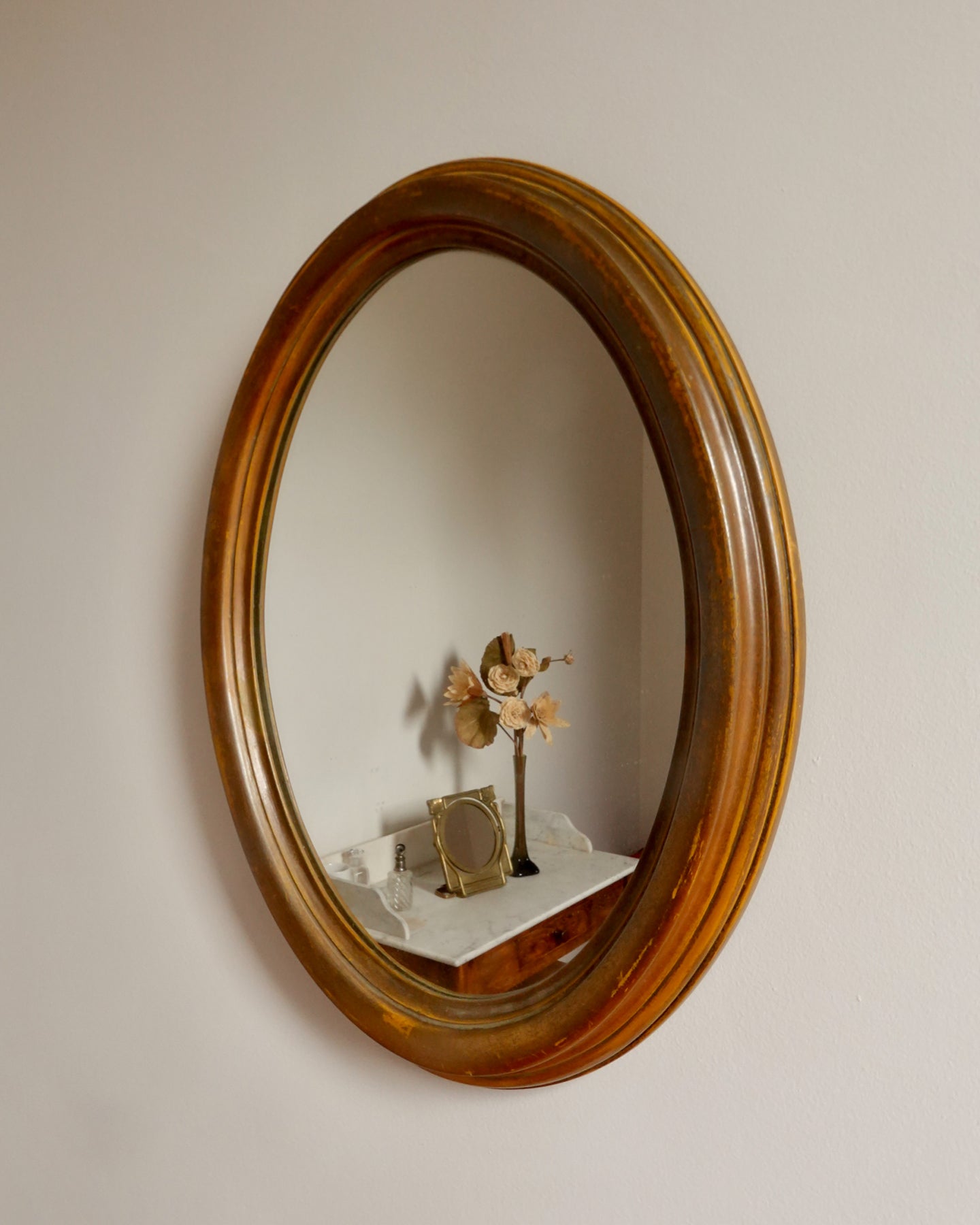 Miroir mural ancien ovale avec cadre en bois patiné, charme classique et authentique